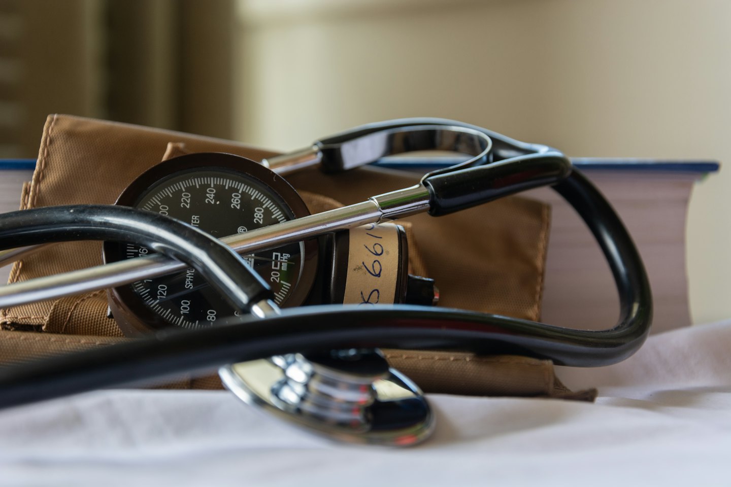 Stethoscope resting on a blood pressure monitor and its case.